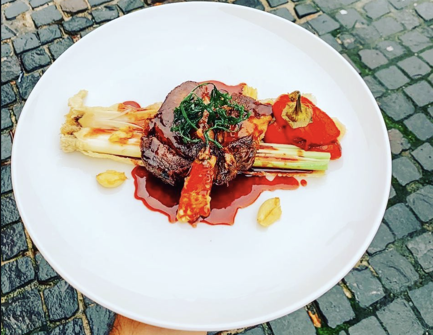 Farfurie fine dining cu carne, legume coapte și sos intens