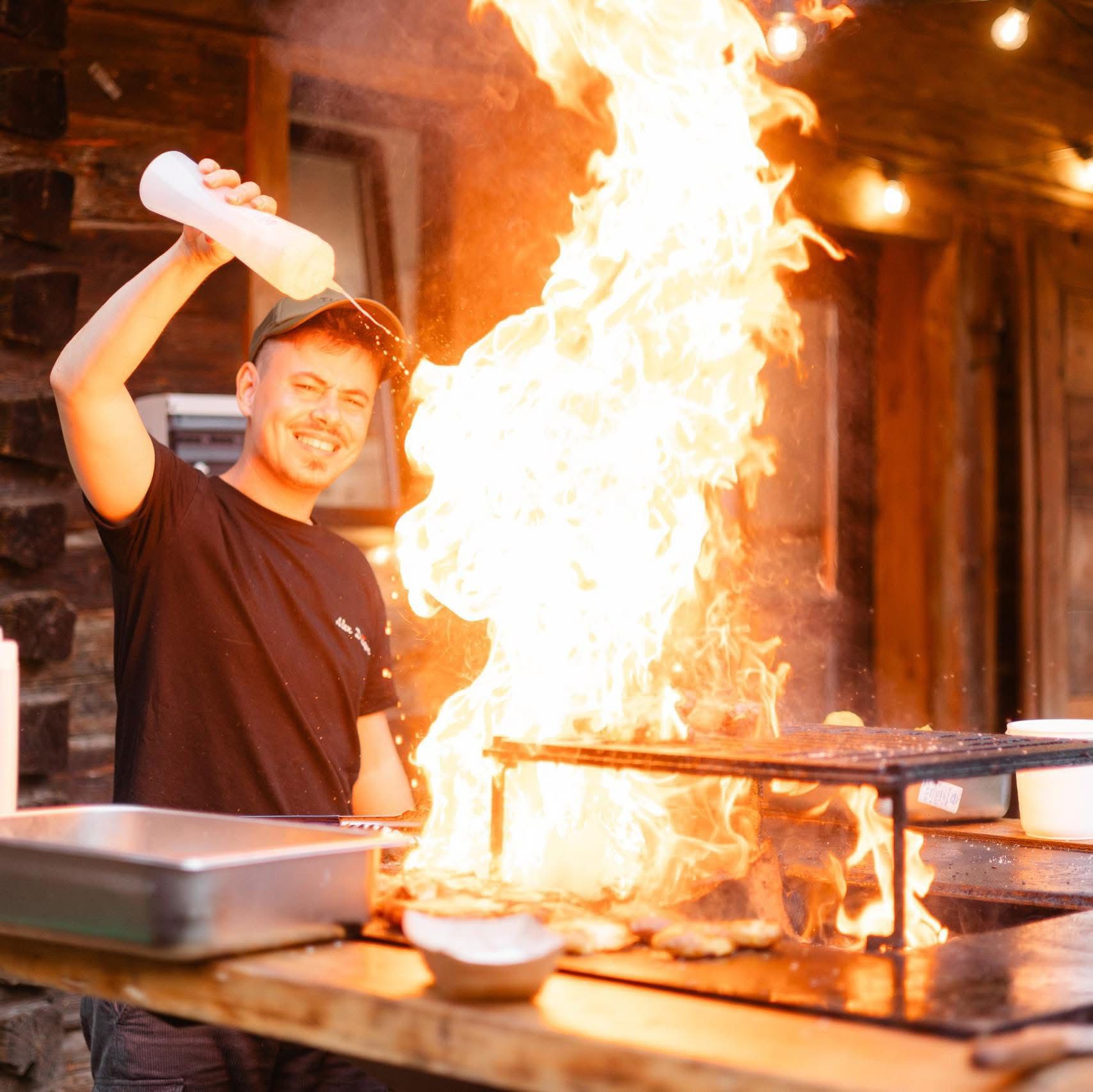 Alex Drăgan — bucătar BBQ, lângă grătarul cu jar viu